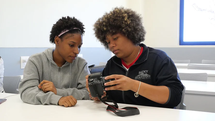 Dos estudiantes revisan la configuración de la cámara. 